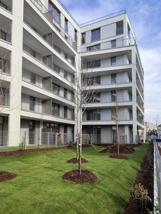 Extérieur d'un ensemble résidentiel moderne avec immeubles d'appartements à façades blanches et balcons filants