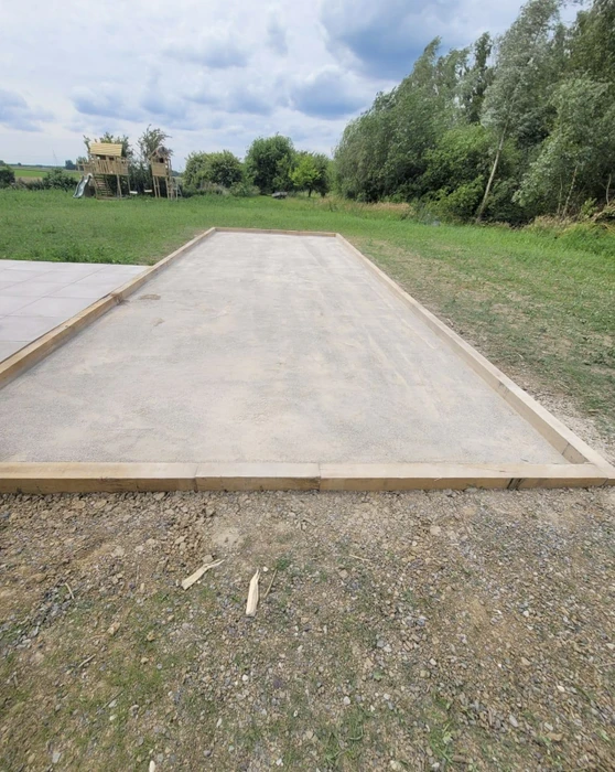 Aménagement paysager contemporain sur terrasse d'immeuble résidentiel avec jardinières cylindriques métalliques contenant palmiers et végétation méditerranéenne
