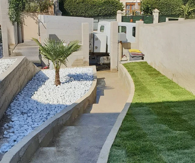 Jardin résidentiel avec allée de pas japonais en pierre naturelle traversant une pelouse verte entretenue