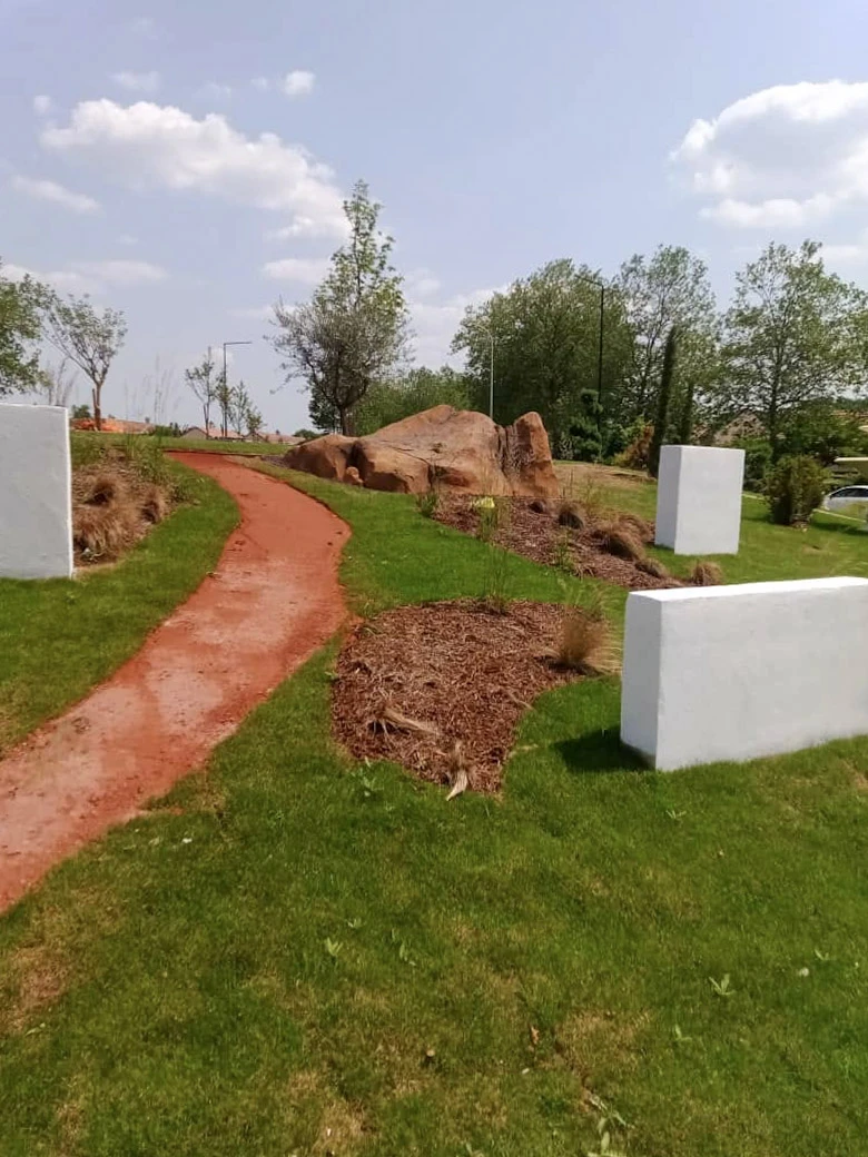 Jardin résidentiel avec aménagement paysager comprenant massifs floraux délimités par bordures de galets blancs